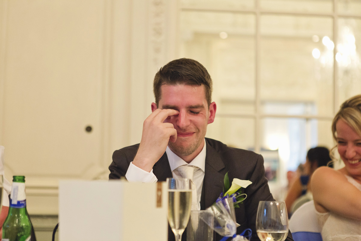 A groom looking embarrassed during the speeches at his wedding