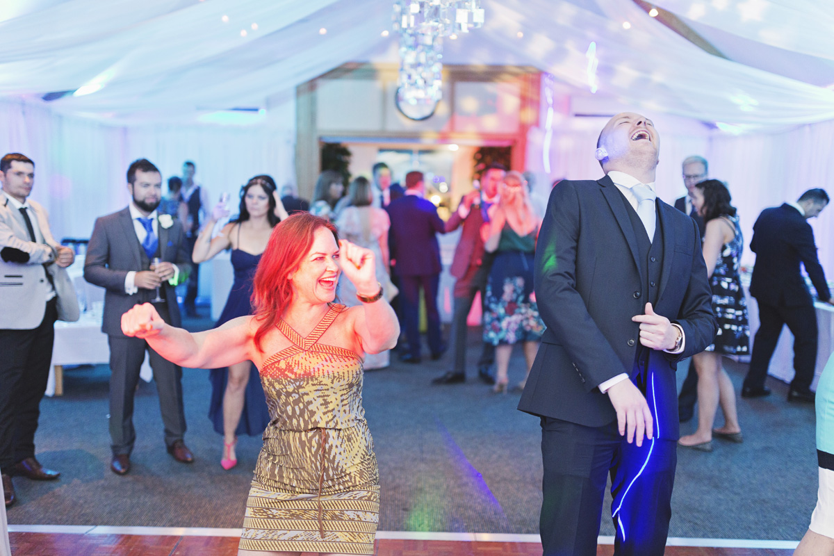 Guests laughing while dancing at a wedding reception