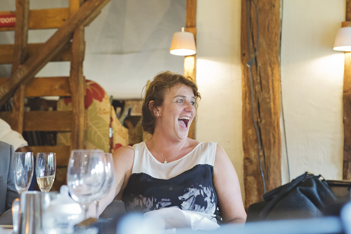 A wedding guest laughing out loud at the speeches