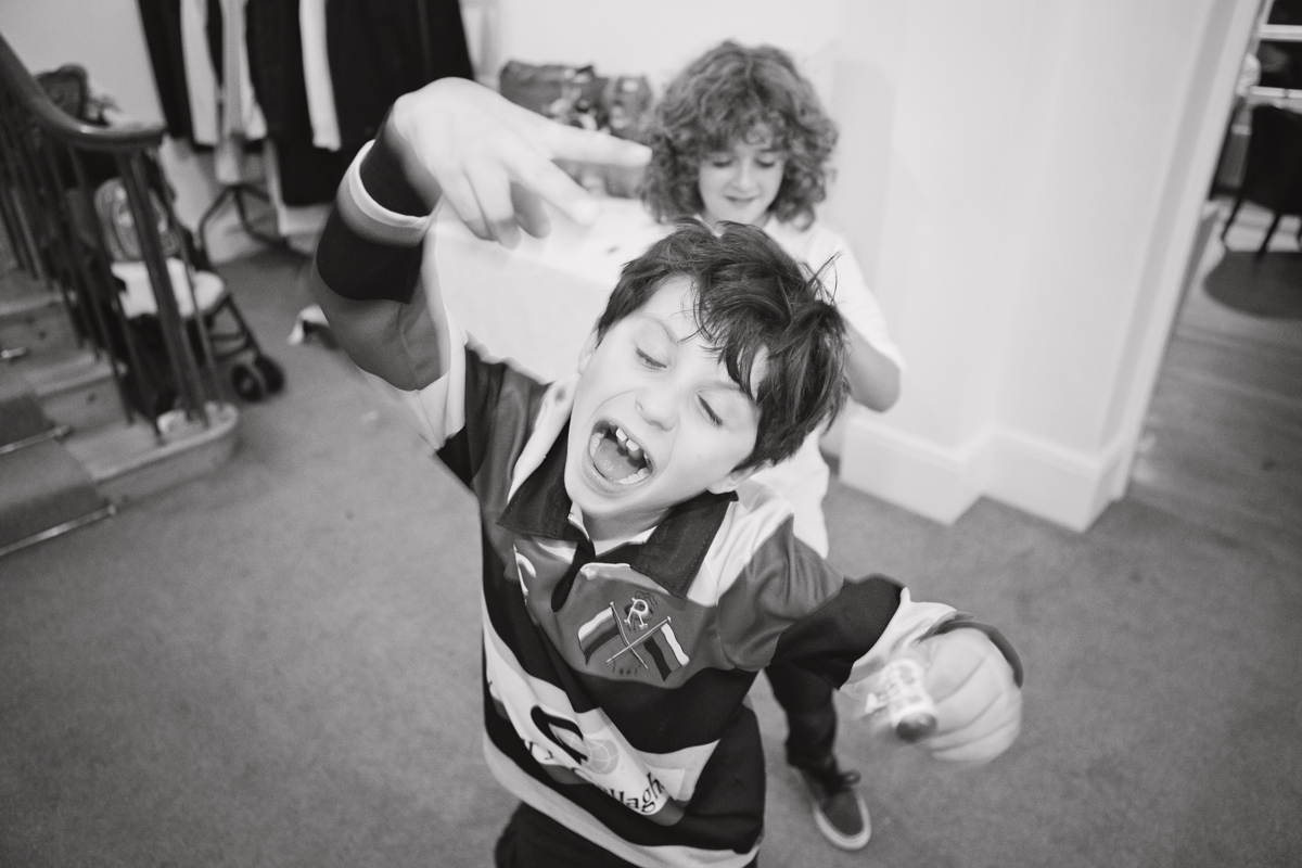 Two boys dance towards the camera during a wedding reception