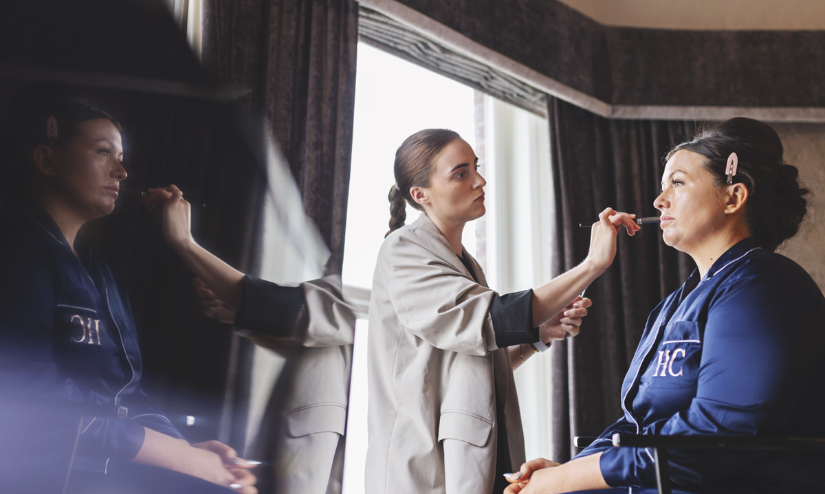 A bridesmaid having her makeup applied before a wedding 