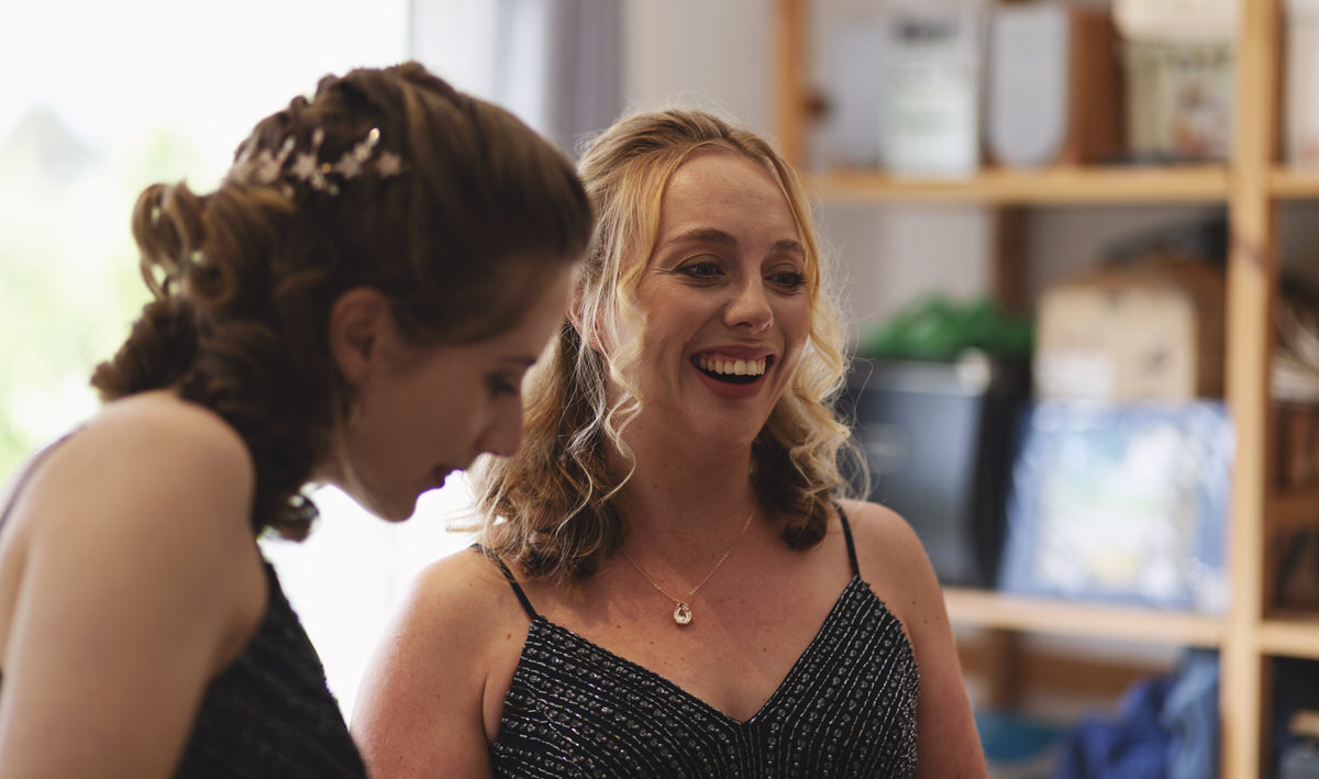 bridesmaids laughing together while they get ready for a wedding