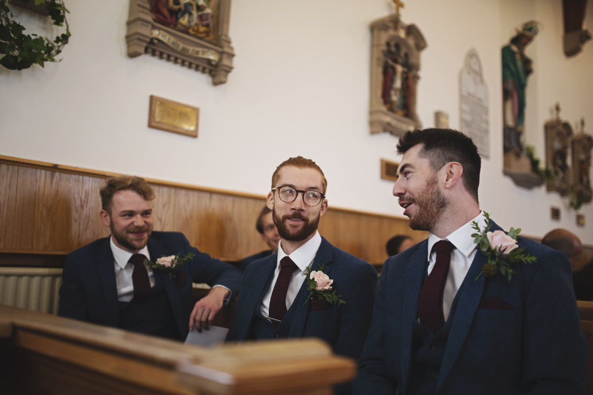 A groom and best man share a joke before a wedding ceremony