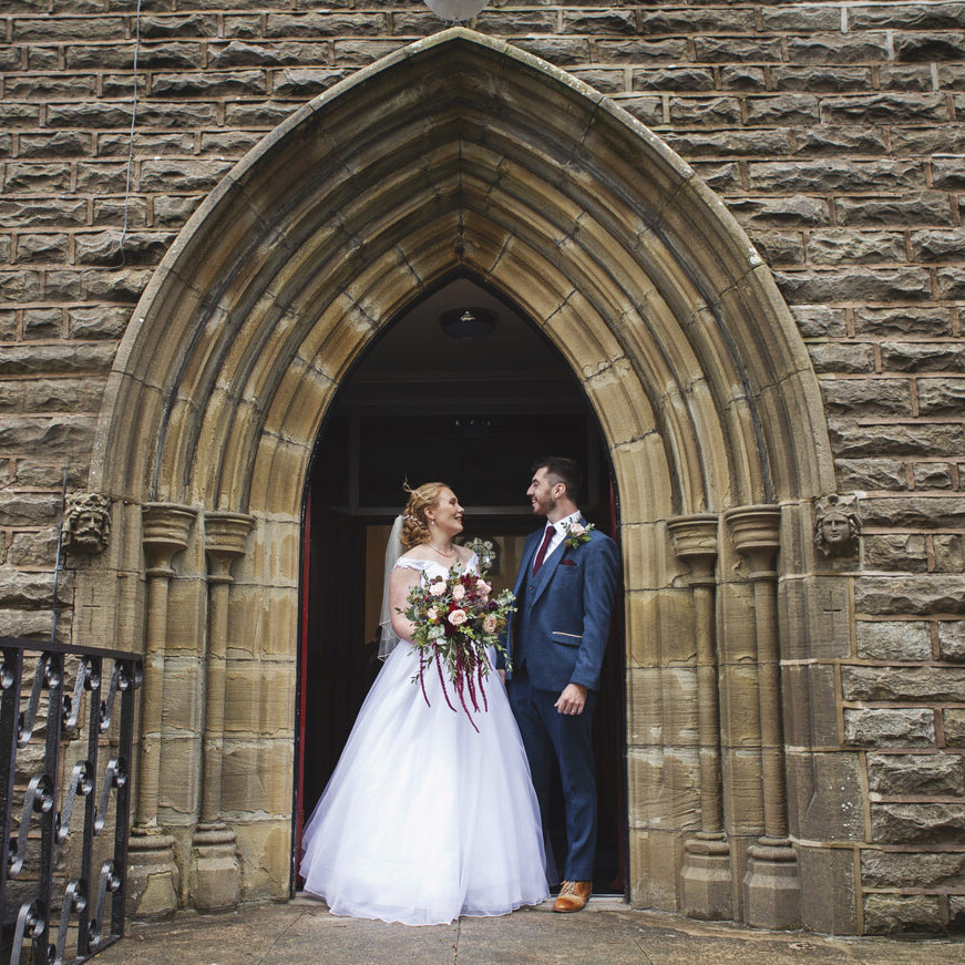 Newlyweds standing in a Church archway